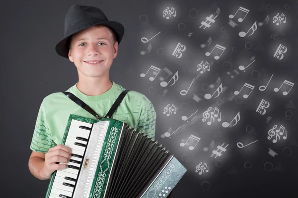 Маленький музыкант в шляпе играет на аккордеоне — стоковое фото