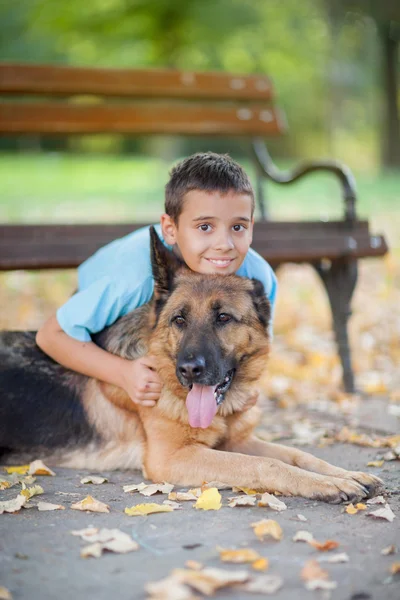 Bambino con un cane pastore tedesco nel parco — Foto Stock