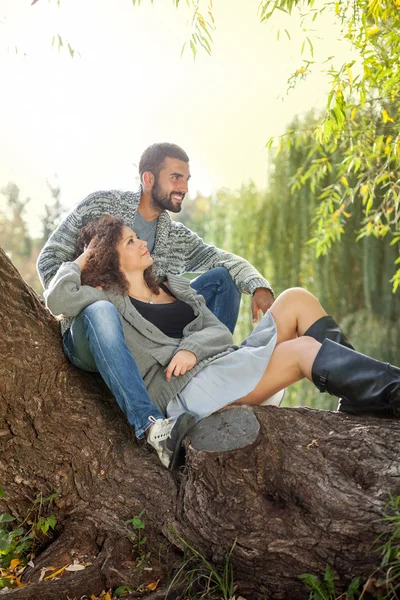 Jovem e sorridente casal relaxante no parque — Fotografia de Stock