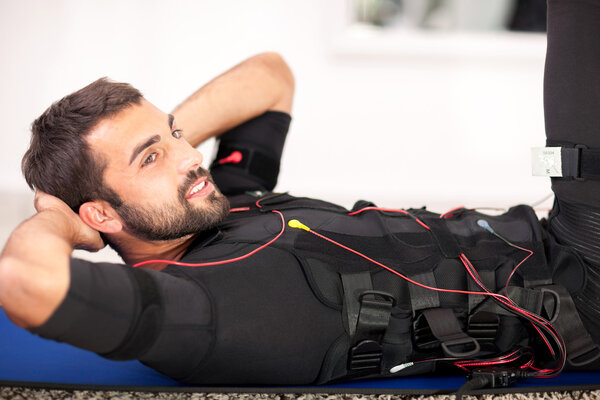 fit man exercise on  electro muscular stimulation machine