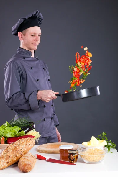 Chef profesional arroja comida en la sartén —  Fotos de Stock