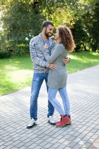 Heureux jeune couple marchant dans le parc embrassé jeune couple dans le — Photo