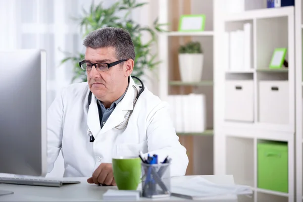 Sorrindo médico sênior moderno com óculos no escritório — Fotografia de Stock