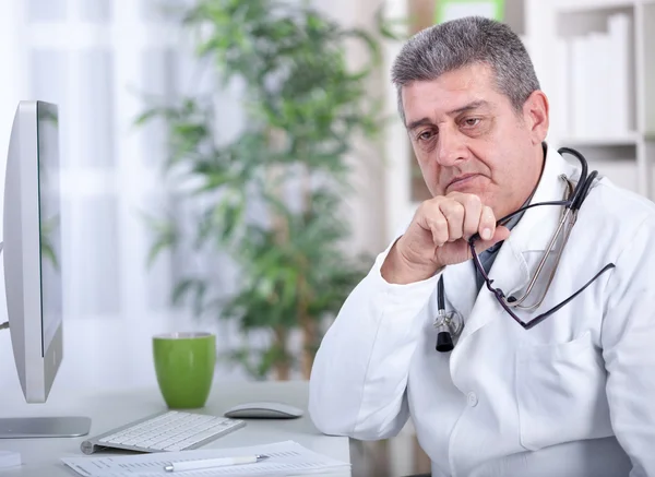 Médico sênior moderno sério com óculos no escritório — Fotografia de Stock