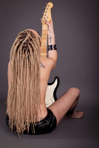 Beautiful punk girl with lots of tattoos posing with guitar — Stock Photo, Image