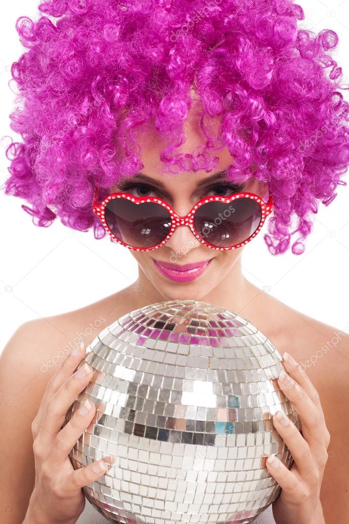 Beautiful young girl with pink wig holding  disco ball,isolated