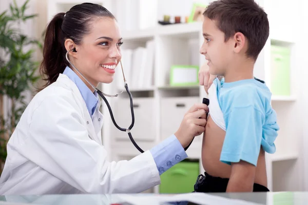 Médico auscultar a un niño con un estetoscopio en el examen — Foto de Stock