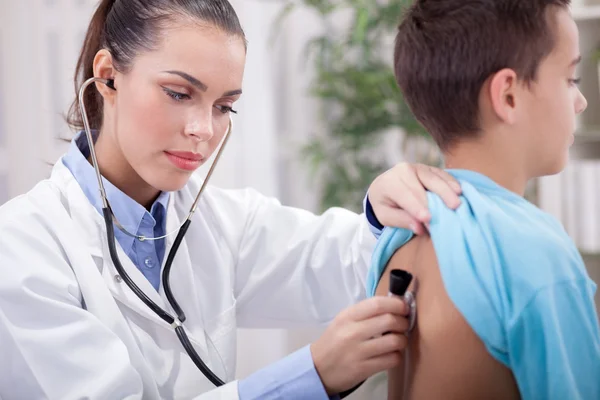 Médecin examinant la respiration d'un enfant en salle d'examen — Photo