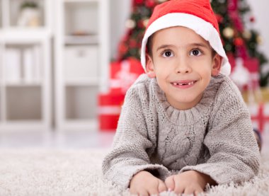 Yılbaşı gecesini gülümseyen kırmızı Noel Baba şapkası olan küçük çocuk Chris