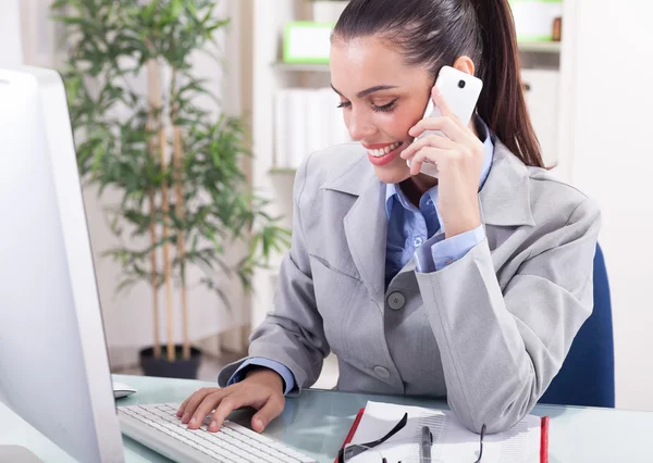 Concepto de negocio - empresaria hablando por teléfono en la oficina — Foto de Stock