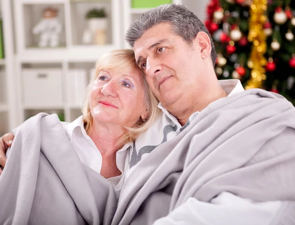 Idősebb pár karácsonyi ül otthon mosolyogva portréja — Stock Fotó