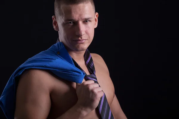 Muskulös sexig man poserar i en slips på svart bakgrund — Stockfoto