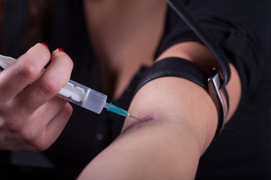 Karanlık adam eylem içinde şırınga uyuşturucu bağımlısı genç kadın