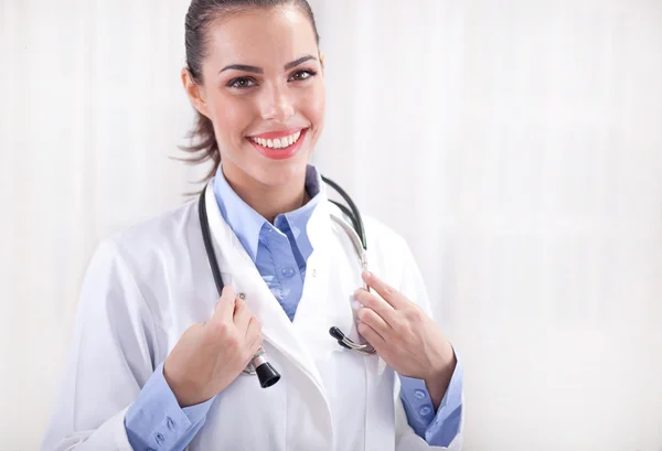 Conceito de medicina - médico fêmea sorridente com coração e estetosc — Fotografia de Stock