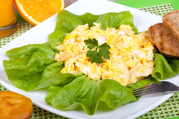 Roerei met met sinaasappel en geroosterd brood — Stockfoto