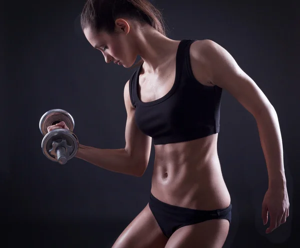 Sexy young fit woman lifting dumbell — Stock Photo, Image