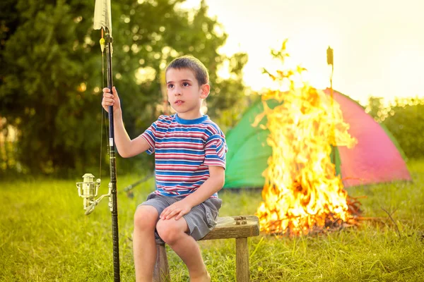 Criança em uma viagem de acampamento aprendendo a usar a vara de pesca — Fotografia de Stock