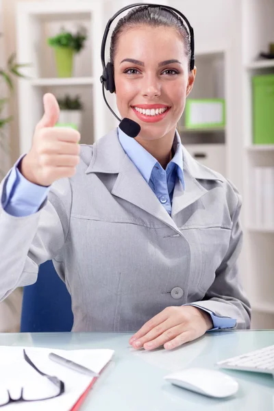 Hermoso operador de teléfono de soporte en auriculares en el lugar de trabajo — Foto de Stock