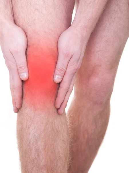 Ein junger Mann massiert ihr schmerzhaftes Knie — Stockfoto