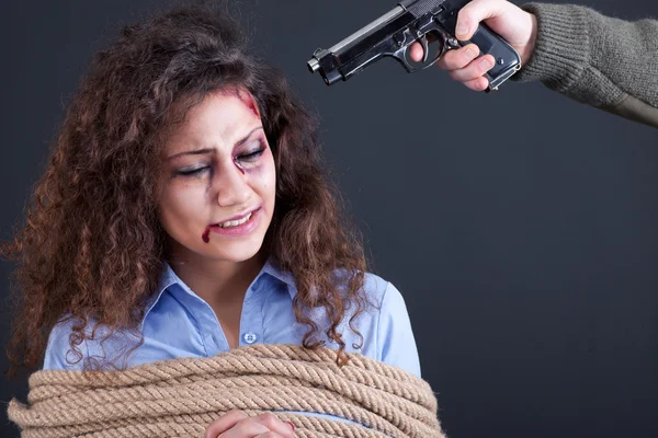 Terrorists threatening the a frightened girl with gun — Stock Photo, Image