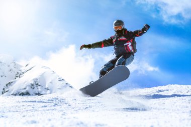 Jumping snowboarder from hill in winter clipart