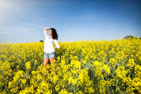 Beautiful happy woman in canola field — Stock Photo, Image