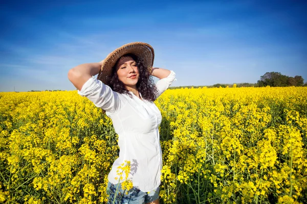 Hermosa mujer feliz en canola campo en día soleado — Foto de Stock