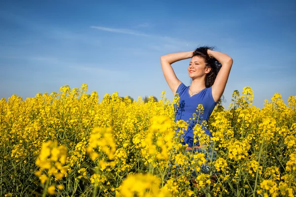 Όμορφη ευτυχισμένη γυναίκα στον τομέα canola στην ηλιόλουστη ημέρα — Φωτογραφία Αρχείου