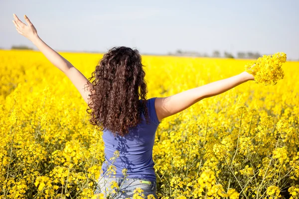 Ευτυχισμένη γυναίκα στον τομέα canola στην ηλιόλουστη ημέρα — Φωτογραφία Αρχείου