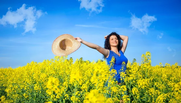 Beautiful happy woman in canola field in sunny day — Stock Photo, Image