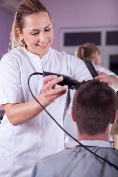 Peluquero mujer cortar el cabello con clipper —  Fotos de Stock