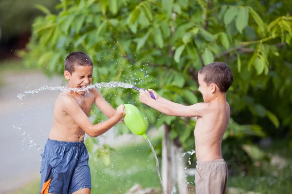 Crianças felizes fora em um dia de verão, pulverizado com balões fi — Fotografia de Stock