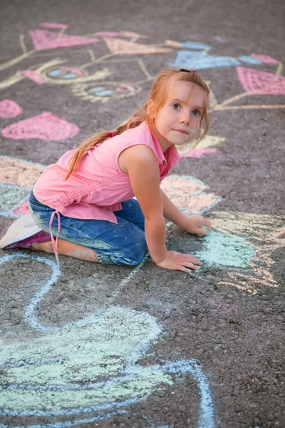 Little girl draw colored chalk on asphalt — Stock Photo, Image