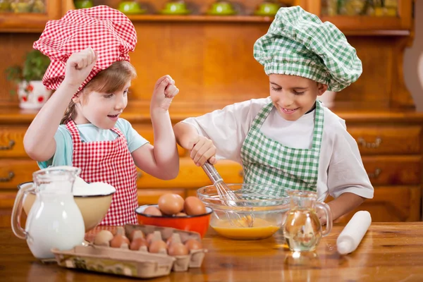 Dos niños felices preparando huevos para galletas en la cocina — Foto de Stock