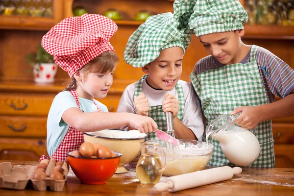 Τρεις μικρό παιδί προετοιμασία συστατικά για μπισκότα στην κουζίνα — Φωτογραφία Αρχείου