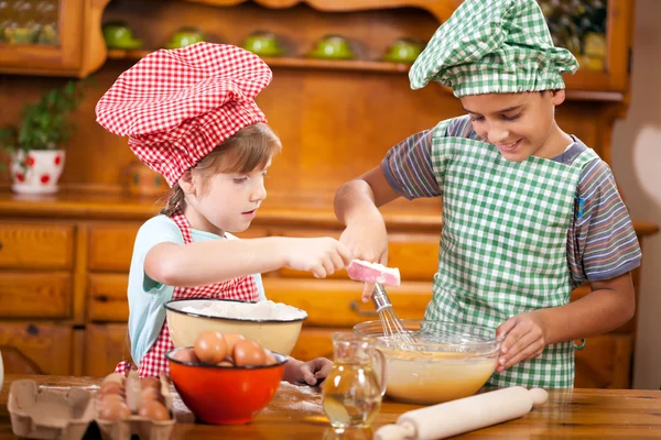 Bruder und Schwester bereiten Zutaten für Kuchen zu — Stockfoto