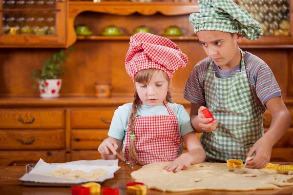 Due bellissimi bambini caucasici che fanno una torta — Foto Stock