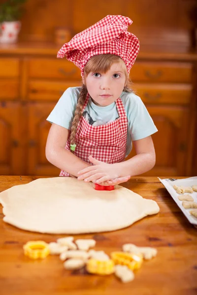 Νεαρό κορίτσι ζύμωμα ζύμη για να φτιάξετε τα γλυκάκια στην κουζίνα — Φωτογραφία Αρχείου