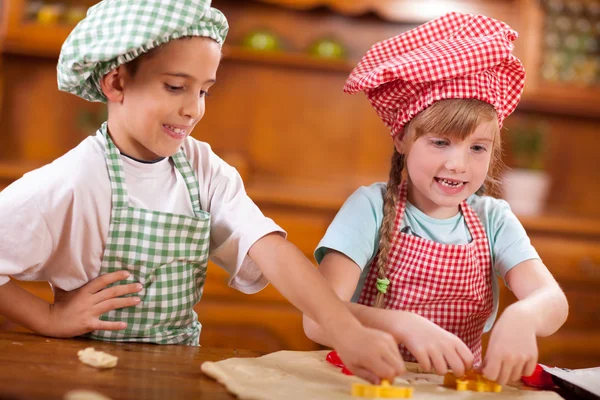 Щасливі діти грають шеф-кухаря на кухні — стокове фото