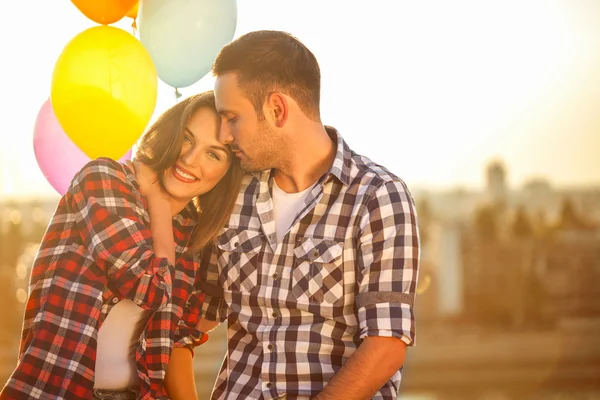 Jong (echt) paar met ballonnen liefdevolle elkaar buitenshuis — Stockfoto