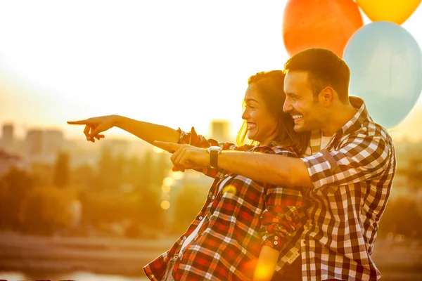 Mladý, usměvavý pár v lásce s balónky, navzájem se milovat — Stock fotografie