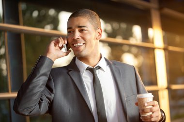 Cep telefonunuzda konuşuyor ve gülümseyen başarılı afro iş adamı