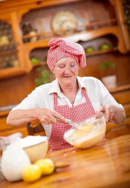 Senior or older woman  cooking in kitchen — Stock Photo, Image