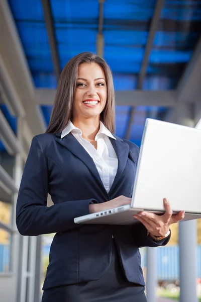 Jonge succesvolle zakenvrouw met een laptop in de buitenlucht — Stockfoto