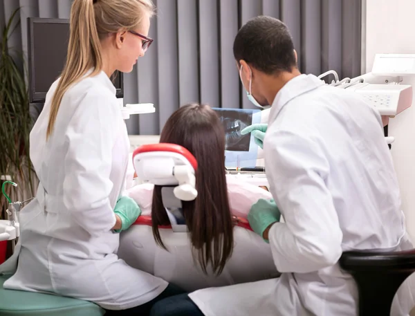 Tandläkare förklara detaljerna i röntgen bild till sin patient — Stockfoto