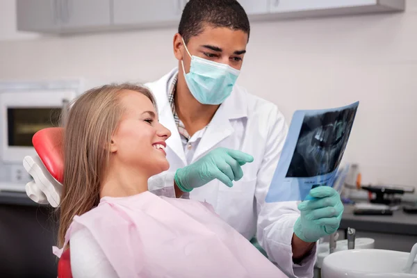 Dentista explicando os detalhes da imagem de raios-x para seu paciente — Fotografia de Stock