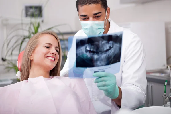 Dentista explicando los detalles de la radiografía a su paciente — Foto de Stock