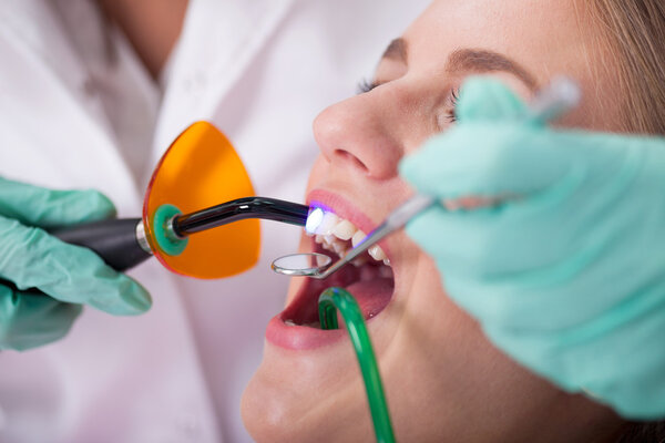 стоматолог лечит зубы пациентки, крупным планом
.