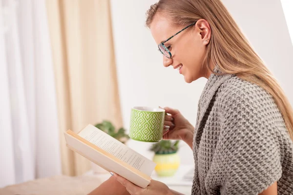 Femme sur le lit avec vieux livre et tasse de café — Photo