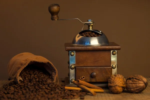 Granos de café tostados y molinillo de café sobre fondo oscuro —  Fotos de Stock